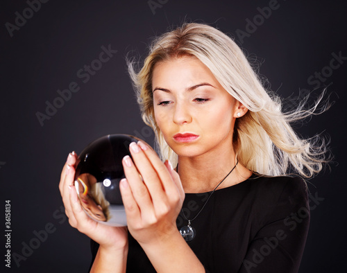 Foto: Young woman with crystal ball. Young woman with crystal ball.
