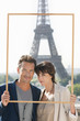Foto: Portrait of a couple framing their dream vacation with Eiffel Tower, Paris, Ile-de-France, France Portrait of a couple framing their dream vacation with Eiffel Tower, Paris, Ile-de-France, France