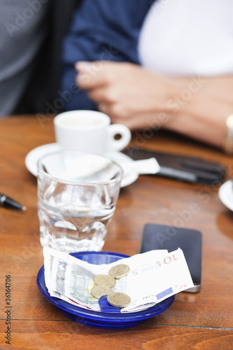 Photo: Euro banknotes and coins with bill on a table in a restaurant, Paris, Ile-de-France, France Euro banknotes and coins with bill on a table in a restaurant, Paris, Ile-de-France, France