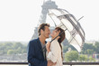 Photo : Couple under an umbrella with the Eiffel Tower in the background, Paris, Ile-de-France, France Couple under an umbrella with the Eiffel Tower in the background, Paris, Ile-de-France, France