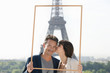 Foto: Couple framing their dream vacation with Eiffel Tower in the background, Paris, Ile-de-France, France Couple framing their dream vacation with Eiffel Tower in the background, Paris, Ile-de-France, France