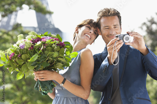 Photo: Woman holding a bouquet of flowers and man showing pictures in a digital camera with the Eiffel Tower in the background, Paris, Ile-de-France, France Woman holding a bouquet of flowers and man showing pictures in a digital camera with the Eiffel Tower in the background, Paris, Ile-de-France, France