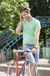 Photo: Man walking with a bicycle and talking on a mobile phone, Paris, Ile-de-France, France Man walking with a bicycle and talking on a mobile phone, Paris, Ile-de-France, France