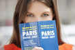 Photo: Portrait of a woman holding a travel guidebook in front of her face, Paris, Ile-de-France, France Portrait of a woman holding a travel guidebook in front of her face, Paris, Ile-de-France, France