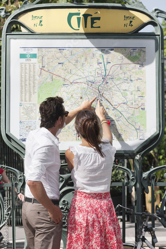 Photo: Couple pointing at a map, Paris, Ile-de-France, France Couple pointing at a map, Paris, Ile-de-France, France