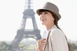 Photo: Woman holding a guide book with the Eiffel Tower in the background, Paris, Ile-de-France, France Woman holding a guide book with the Eiffel Tower in the background, Paris, Ile-de-France, France