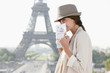 Photo: Woman holding a guide book with the Eiffel Tower in the background, Paris, Ile-de-France, France Woman holding a guide book with the Eiffel Tower in the background, Paris, Ile-de-France, France