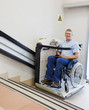 man in an invalid chair walks upstairs