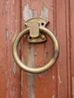 A brass ring as a door knocker on an old wooden door
