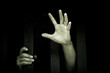 Human hand stretch out  from prison bars