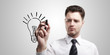Business man drawing a light bulb on a glass screen Business man drawing a light bulb on a glass screen