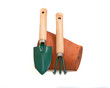 Miniature gardening tools resting on a terrcota flowerpot.