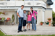 Caucasian family standing in front of house