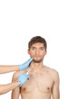 Photo: hands in blue gloves hold attractive young male face hands in blue gloves hold attractive young male face