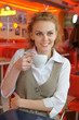 Foto: Young pretty woman in street cafe with cup Young pretty woman in street cafe with cup