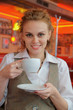 Foto: Young pretty woman in street cafe with cup Young pretty woman in street cafe with cup