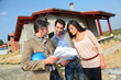 Entrepreneur showing house under construction to couple Entrepreneur showing house under construction to couple
