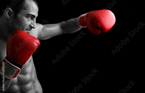 Foto: Young Boxer fighter over black background Young Boxer fighter over black background