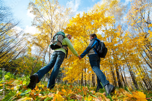 Photo: Happy young couple with backpacks in the park Happy young couple with backpacks in the park