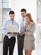 Young businesspeople looking at laptop screen Young businesspeople looking at laptop screen