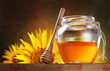 Honey in a glass jar and flower sunflower