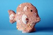 gebastelter Fisch aus Ton mit Muscheln blauer Hintergr.