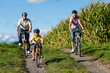 Family is cycling in summer
