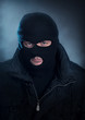 Burglar in black balaclava at night