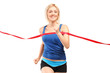 A female runner running towards a finish line