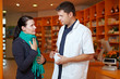 Frau mit Halsschmerzen in Apotheke