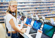 Happy young lady in consumer electronics store