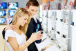 Happy couple at consumer electronics shop buying digital camera Happy couple at consumer electronics shop buying digital camera