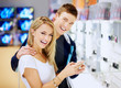 Smiling young couple in electronics store with digital camera Smiling young couple in electronics store with digital camera
