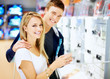 Young couple in electronics shop with digital camera Young couple in electronics shop with digital camera