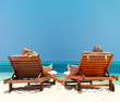 Romantic couple holding hands and relaxing on beach