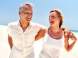 Happy mature couple enjoying together at the beach Happy mature couple enjoying together at the beach