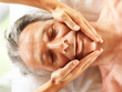 Mature man getting a massage at spa salon
