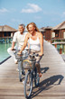 Happy mature couple enjoying cycle ride at beach resort