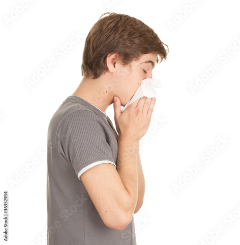 Photo: sick young man with flu blowing her nose sick young man with flu blowing her nose