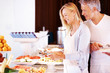 Mature man and woman at hotel buffet choosing food to eat