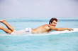 Photo: Young guy on surfboard paddling out to meet the waves Young guy on surfboard paddling out to meet the waves