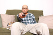Asian man with remote watching television.