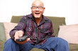 Asian man with remote watching television.