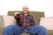 Asian man with remote watching television.