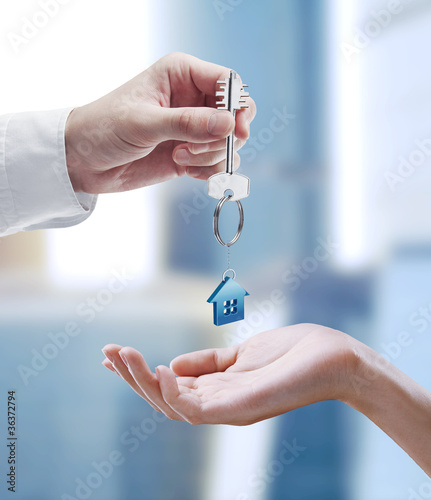 Foto: Man is handing a house key to a woman Man is handing a house key to a woman