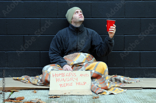 Photo: Young man begs on sidewalk Young man begs on sidewalk