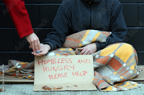 Photo: Woman gives change to begging man on street Woman gives change to begging man on street