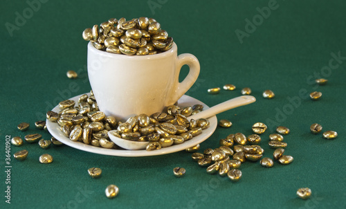 Photo: tazzina con chicchi di caffè dorati tazzina con chicchi di caffè dorati