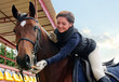 Portrait of smiling woman feeding purebred horse