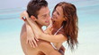 Portrait of cheerful young couple hugging each other on beach